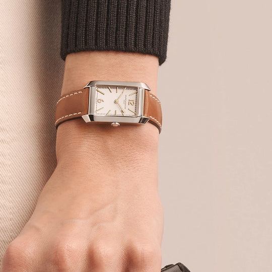 Baume & Mercier Classima er en rektangulær klokke til dame med quartzverk, hvit skive og brun skinnrem.