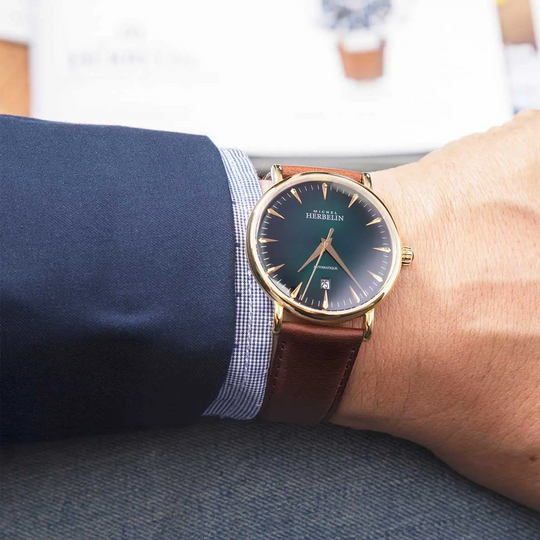 Herbelin Inspiration – elegant sveitsisk automatisk klokke med brun urskive og brun lærrem, klassisk design som passer til både jobb og formelle anledninger.