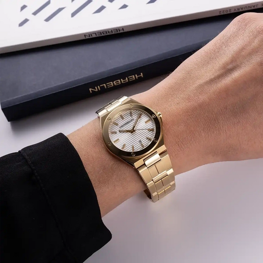 Herbelin Cap Camarat 14545BP1N11 er en gullfarget dameklokke i stål med sølvfarge tallskive, lenke og quartzverk.